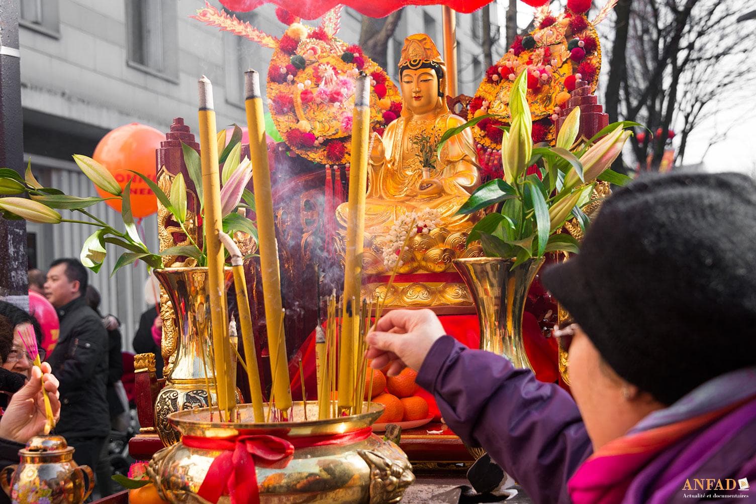 Nouvel an chinois 2013 - Une dame met de l'encens devant une statue de Bouddha