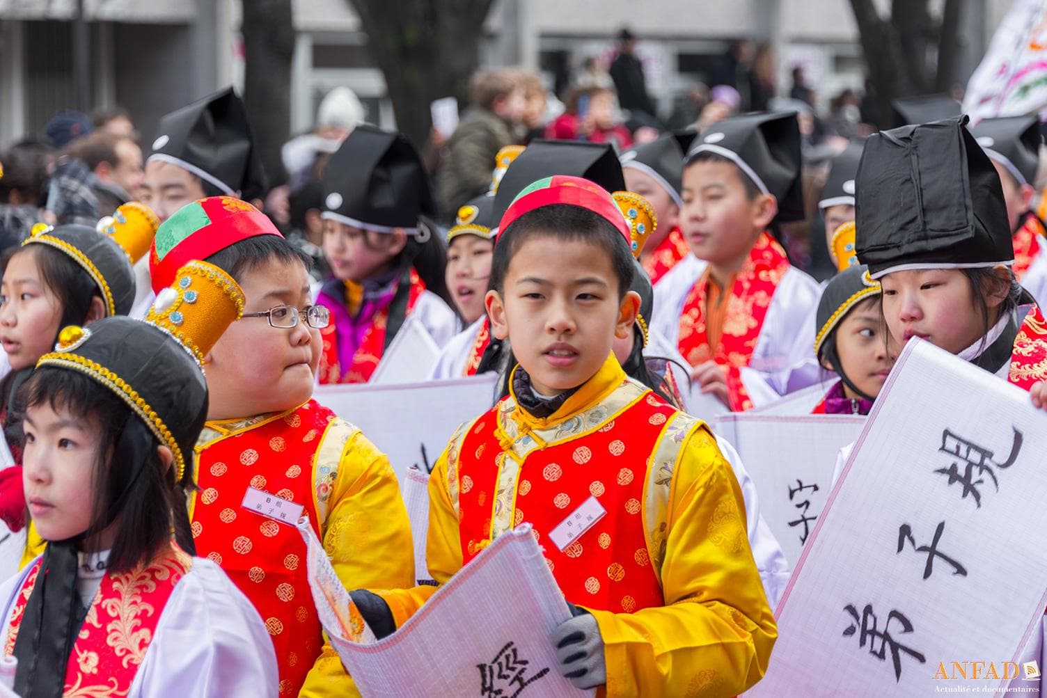 Nouvel an chinois 2013 - Des enfants en costumes défilent avec des écriteaux